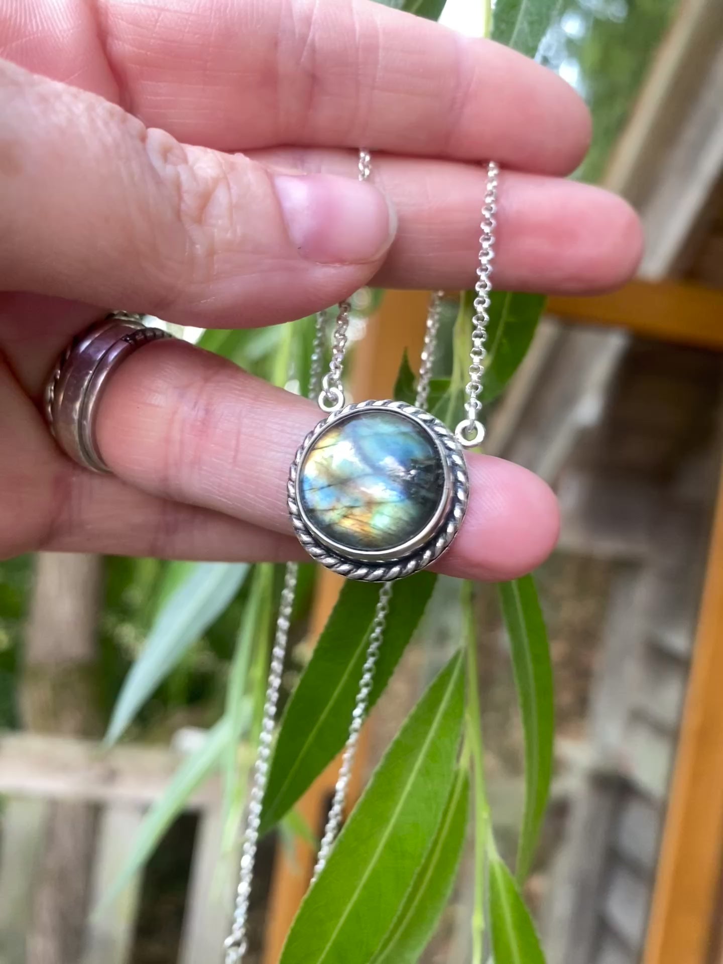 Labradorite necklace moving with green background 